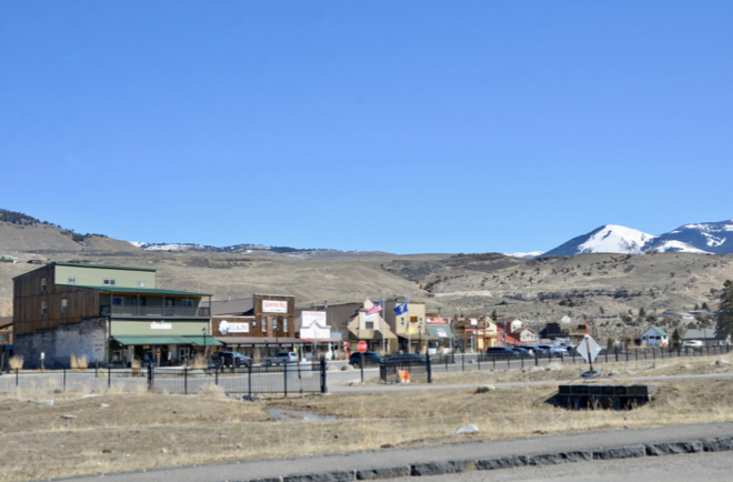 Gardiner, Montana storefronts below a snow-capped peak