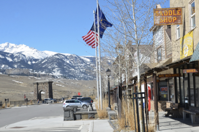 The Saddle Shop and Roosevelt Arch with snowy mountains behind