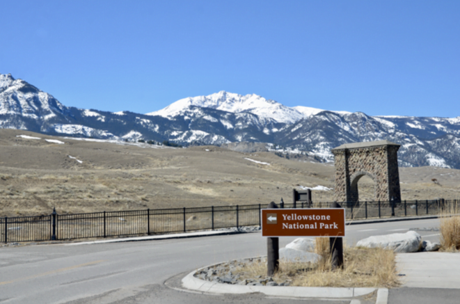 Yellowstone National Park sign with the Roosevelt Arch beyond